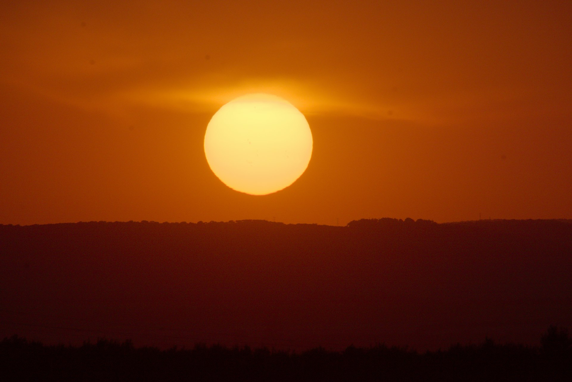 the sun is setting in the sky over the mountains